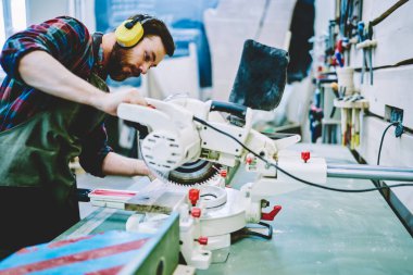 Kafkasyalı ustabaşı DIY el yapımı hobi sırasında elektronik daire kullanıyor. Kendi imalat restorasyonunda ahşap ahşap kaplama yapıyor. Profesyonel bir ustabaşı kapalı alanda inşaat işine odaklanıyor.