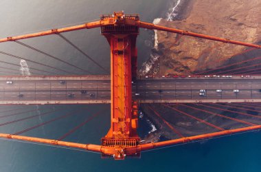 Golden Gate Köprüsü 'nün akşam üstü sisli görünümü, metropoliten ulaşım altyapısı, süspansiyon inşaatı yolunda giden otomobil araçlarının kuş bakışı görüntüsü. 