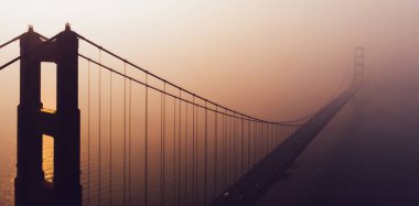 Golden Gate Köprüsü 'nün sisli günbatımında San Francisco' daki hava manzaralı silueti manzara süspansiyon inşaatı, metropoliten ulaşım altyapısı. Kaliforniya dönüm noktası 