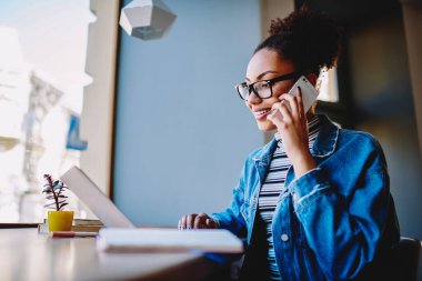 Yeni nesil hippi kız, bilgisayardaki internet bağlantısı hakkında sağlayıcıyla iletişim kurmak için müşteri hizmetlerine e-posta yazarken arkadaşlarıyla akıllı telefon aygıtıyla konuşuyor.