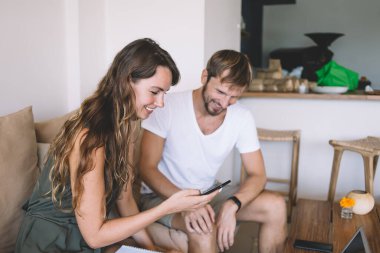 Mutlu erkek ve kadın birlikte vakit geçirerek komik web sitelerinde sanal insanlarla sosyalleşmeye çalışıyor, neşeli kadın blogcu 4G kablosuz internet sayfasında yazı yayınlıyor.