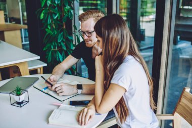 Milenyum erkek ve bayan öğrencileri ders kitaplarıyla üniversite sınavlarına hazırlanmaktan ve cep telefonuyla mesajlaşmak için zaman harcamaktan keyif alıyorlar, genç hipsterler canlı iletişimi görmezden geliyorlar.