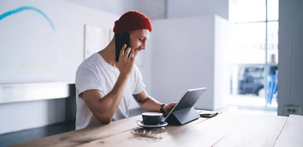 Widok Boku Modnego Hipstera Białej Koszulce Czerwonej Beany Pomocą Tabletu — Zdjęcie stockowe