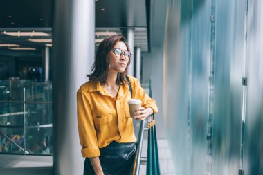 Düşünceli bayan öğrenci, kapalı alanlarda düşüncelere dalmış, boş zamanlarında fikirleri düşünüyor, modaya uygun klasik gözlüklü dalgın hippi kız, görüş düzeltmesi için dikkatli bakıyor.
