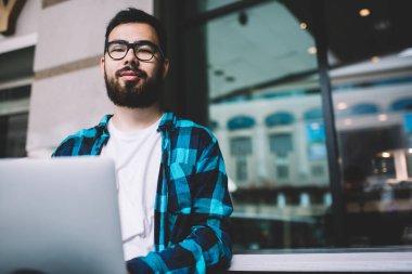 Görüntü koruması için gözlüklü yetenekli Asyalı erkek serbest yazar. Uzaktan kumandalı internet projesinde çalışıyor. Profesyonel sakallı hippi bilgisayarını uzaktan programlamak için kullanıyor.