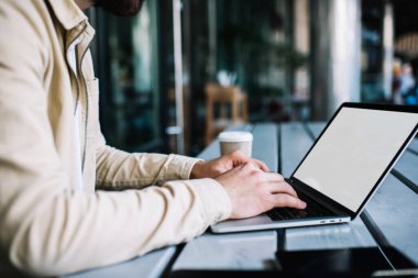 Bilgisayarı kullanan bir adamın kablosuz internet bağlantısı olan bir kafede serbest çalışmak için ekranı taklit ettiği kesilen görüntüler, netbook 'taki klavye metni.