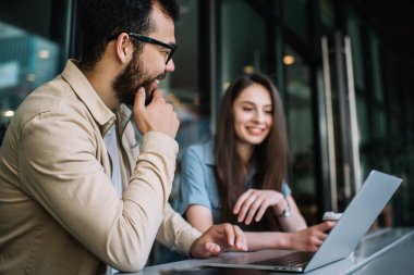 Seçici olarak Asyalı erkek öğrencinin kız arkadaşıyla yaptığı sohbete odaklanın. Birlikte ev ödevi yapmak için dizüstü bilgisayar kullanıyor. Hipster arkadaşlar kafedeki teknolojiyi kullanarak birlikte çalışmaktan zevk alıyor.
