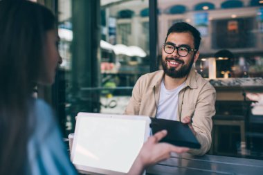 Mutlu Asyalı sakallı adam kitabını kadın meslektaşına veriyor. Uzak bir iş sırasında konuşuyor. Arkadaşları kafeteryada işbirliği yapan dizüstü bilgisayarlardan online ders öğrenirken hediyelerini paylaşıyor.
