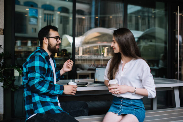 Веселые многорасовые друзья мужского и женского пола обсуждают идеи во время рабочего перерыва в кафе, счастливая пара хипстеров пьет кофе, чтобы выпить чашечку кофе и поговорить в свободное время
