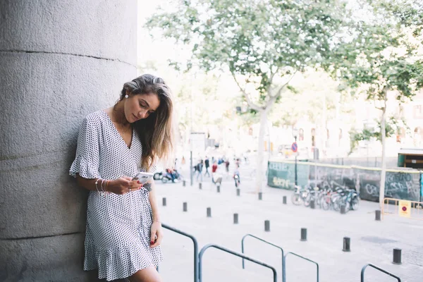 Attractive millennial woman 20 years old reading received email with advices and travel guide around Barcelona city connected to 4g internet in roaming, beautiful hipster girl checking notification