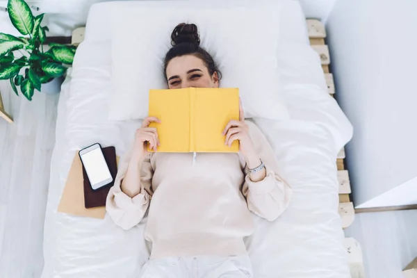 Cima Rindo Encantadora Mulher Fechando Metade Rosto Com Livro Amarelo — Fotografia de Stock