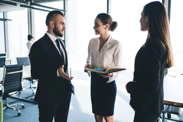 Chico Barbudo Traje Gesticulando Hablando Con Mujeres Elegantes Mientras Está —  Fotos de Stock