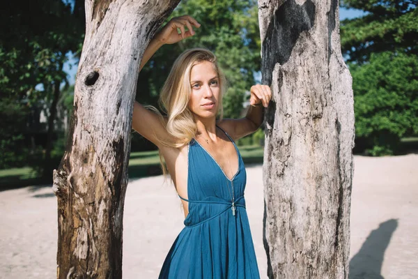 Jonge Langharige Vrouw Elegante Blauwe Jurk Aanraken Bomen Zandstrand Met — Stockfoto