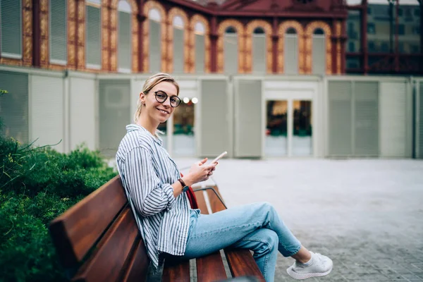 Side View Joyful Blond Female Striped Shirt Jeans Browsing Mobile — Stock Photo, Image