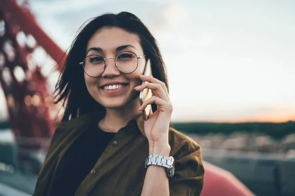 在手机应用的友好漫游交流中 穿着时髦眼镜对着相机微笑的快乐的亚洲青少年的近照 在科技的帮助下戴眼镜的快乐女性的近照 — 图库照片