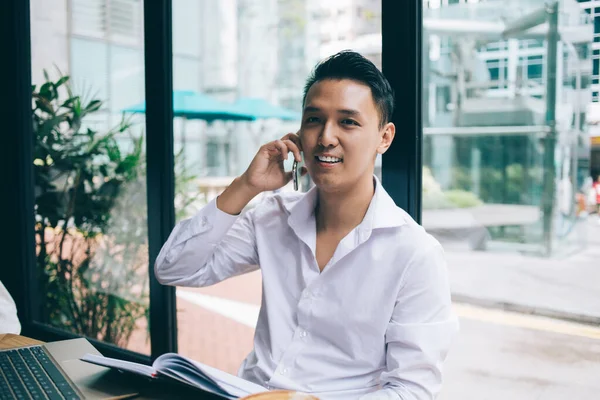 Confiado Hombre Asiático Positivo Camisa Blanca Sentado Mesa Cerca Ventanas —  Fotos de Stock