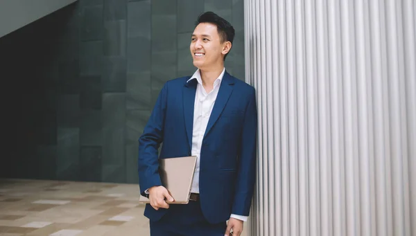 Şık Takım Elbiseli Mutlu Yakışıklı Asyalı Adam Elinde Dizüstü Bilgisayarla — Stok fotoğraf