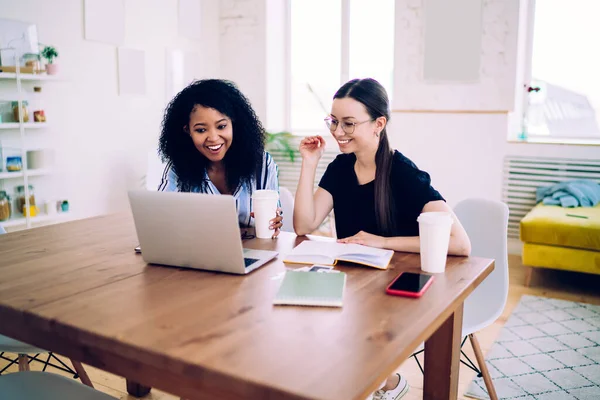 Fröhliche Multiethnische Teenager Freunde Mit Heißgetränk Lächeln Und Benutzen Laptop — Stockfoto