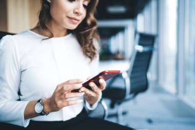 Ürün çekici genç stil gülümseme ofiste sakin kadın şehir ofisinde gündüz otururken akıllı telefon mesajı giyer