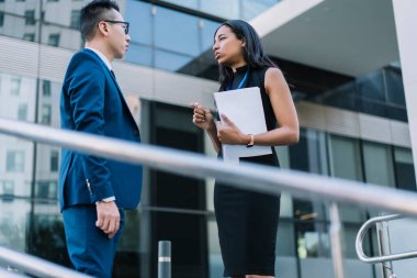 Şehir caddesinde duran ve konferansta iş görüşmeleri yapan zarif kadın ve erkeğin... 