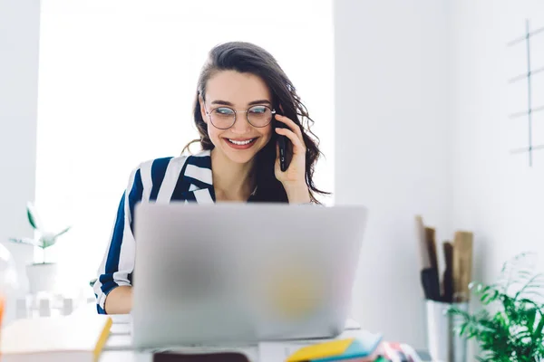 Mörkhårig Söt Kvinna Runda Glasögon Med Toothy Leende Talar Smartphone — Stockfoto