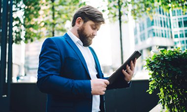 Resmi olarak giyilen seonun yan görünüşü kağıt klasör ve iş sözleşmesi bilgileri şehir merkezinde duruyor, Kafkasyalı ekonomist mali strateji raporunu kontrol ediyor