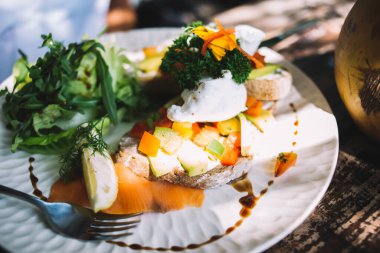 Yukarıdan bruschetta ile servis edilen, haşlanmış sebze karışımı soslu yumurta ve yeşil dereotlu.