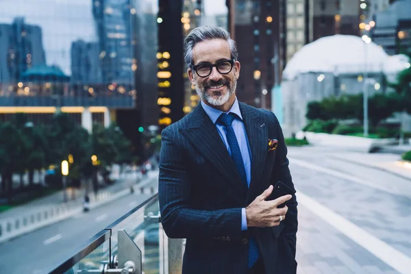 Yakışıklı Orta Yaşlı Gözlüklü Takım Elbiseli Bir Adam Elinde Telefonla — Stok fotoğraf
