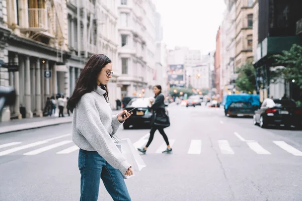 Zijaanzicht Jonge Vrouw Casual Kleding Glazen Kruising Weg Met Boodschappentassen — Stockfoto