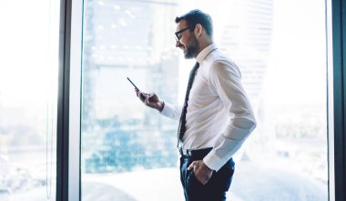 Resmi giyinmiş yetişkin tüccarın yan görünüşü, iş sözleşmesi hakkında olumlu bilgilerle birlikte 4G bağlantısı, ceplerinde el ele tutuşan ve e-posta yazan başarılı adam.