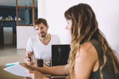 Kısa, basit elbiseli çekici bir kadın defterdeki hesaplamaları gösterirken, sıradan giysili bir adam da mutfakta oturup birlikte yeni bir daire seçiyor.