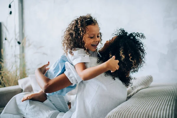 Menina Encantadora Mãe Com Cabelos Cacheados Abraçando Divertindo Sofá Confortável — Fotografia de Stock