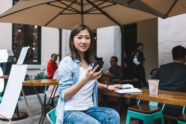 Brunetka Szczęśliwy Azji Kobieta Niebieskiej Koszuli Sms Smartfona Patrząc Aparat — Zdjęcie stockowe