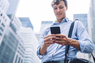 New York 'un göbeğinde telefonla mesajlaşan tişörtlü yakışıklı genç işadamlarından.