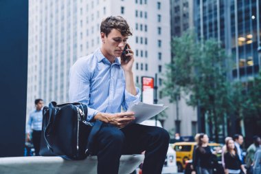 Beyaz erkek profesyonel mali rapordaki bilgileri kontrol ediyor. Sözleşme detaylarını görüşmek için ortağına telefon ediyor. Uluslararası telefon görüşmesi yapan zeki bir tüccar.