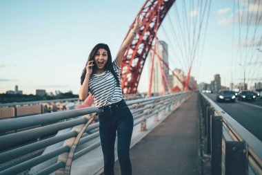 Cep telefonu iletişimi sırasında elini kaldıran harika hipster kızın yarım boy portresi. Gelen uluslararası telefon konuşmasına şaşıran Asyalı kadın.