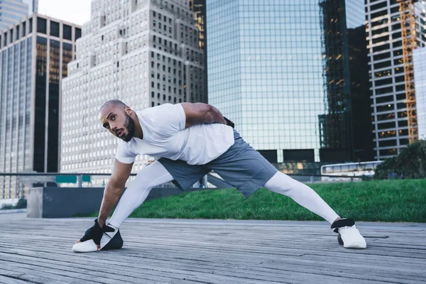 Passar Välbyggd Afroamerikansk Man Sportkläder Sträcker Ben Trä Trottoar Framför — Stockfoto