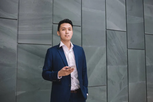 Exitoso Hombre Asiático Guapo Reflexivo Traje Mensajería Teléfono Inteligente Mientras —  Fotos de Stock