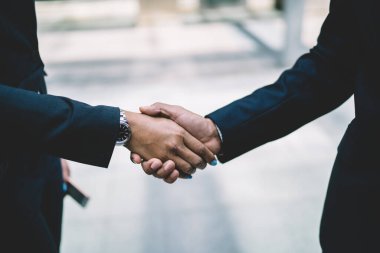 Şehir merkezindeki caddelerde kol saati takılı, resmi siyah takım elbiseli iş arkadaşları el sıkışıyor. Ortaklık toplantısı konsepti. Başarılı bir anlaşma el sıkışması. Selamlama ve destek