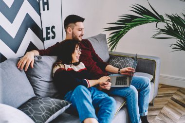 Olumlu kız arkadaş ve erkek arkadaş, evde bedava internet bağlantısı, mutluluk kavramını kullanarak modern netbook üzerinden komedi filmi izledikleri için birlikte vakit geçirmekten rahat hissediyorlar.