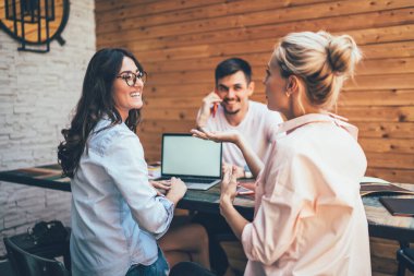 Gülen kadınlar el kol hareketleri yapıp iş hakkında tartışırken aynı anda açık kafedeki masanın etrafında oturan erkek arkadaşlarıyla buluşuyorlar.