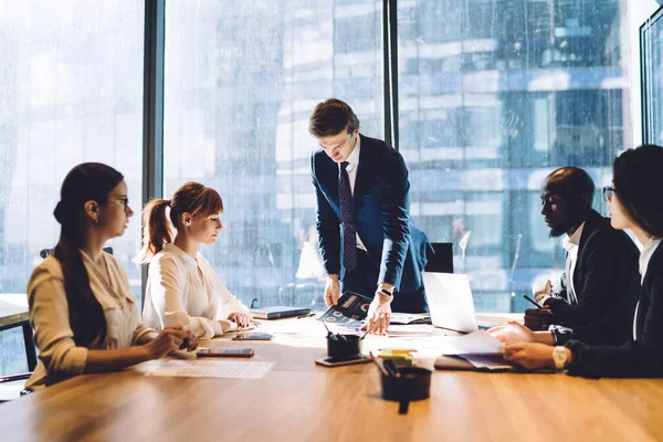 Jonge Zelfverzekerde Baas Onderzoekt Graphics Met Multiraciale Drukke Groep Rond — Stockfoto