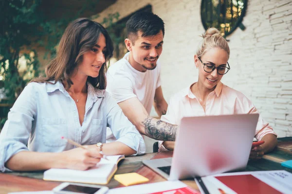 Grupo Personas Sonrientes Concentradas Pie Sentados Mesa Mirando Las Pantallas — Foto de Stock