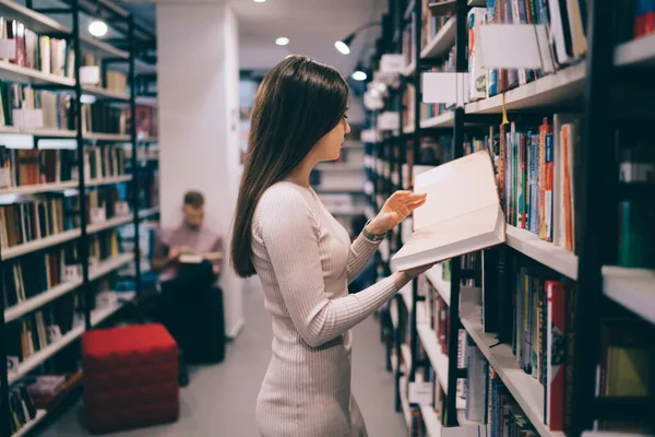 Vue Latérale Belle Femme Mince Debout Devant Bibliothèque Tenant Livre — Photo