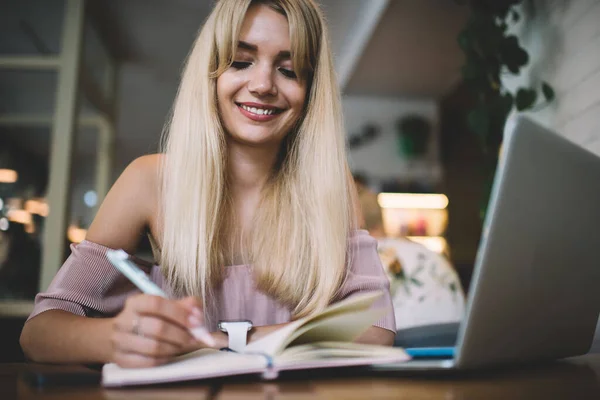 Joven Mujer Rubia Pelo Largo Sonriendo Mientras Escribe Cuaderno Uso — Foto de Stock