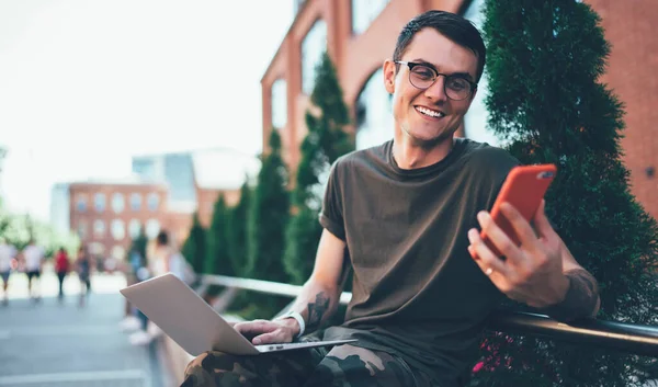 교정을 목격자인 스마트폰 가젯에서 웃으며 현대식 노트북을 캠퍼스에 긍정적 프리랜서인 — 스톡 사진