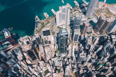 Hong Kong gökdelenlerinin insansız hava aracının panoramik manzarası Metropolitan körfezi ile gökdelenlerin ufuk çizgisi. Şehir merkezinde iş ve finans binaları olan modern beton şehir manzarası. Şehir altyapısı
