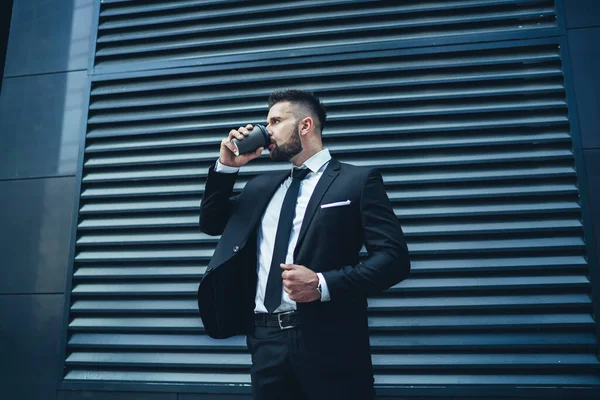 Low Angle Bearded Guy Adjusting Jacket Looking Away While Sipping — Stock Photo, Image
