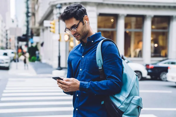 白天站在繁忙的城市街道上 穿着休闲装 戴着眼镜 戴着智能手机的帅气的成年男子 — 图库照片