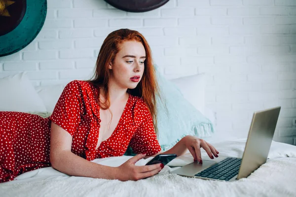 Νεαρή Εστιασμένη Γυναίκα Smartphone Και Κόκκινα Μαλλιά Ξαπλωμένη Στο Κρεβάτι — Φωτογραφία Αρχείου